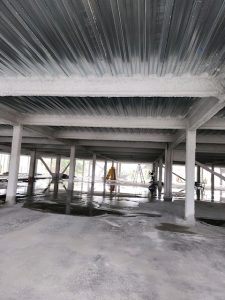 The interior of a industrial structure, with structure beams sprayed with cementitious fireproofing