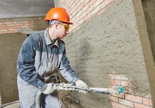 Man applying spray-on Thermal Acoustic Insulation to a wall's interiors